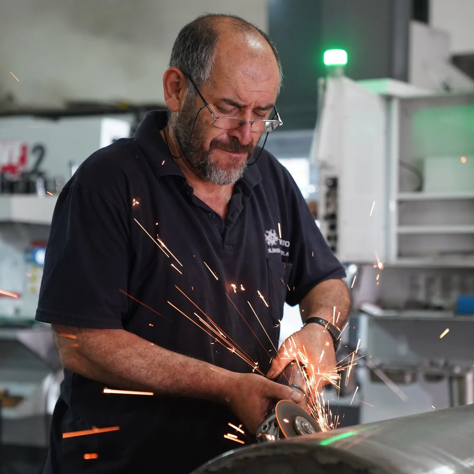 Fabrication specialist precision-grinding a metal component on the production floor